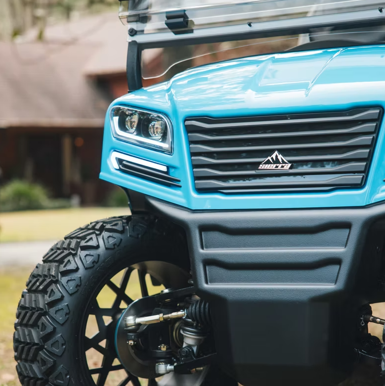 Close-up of a blue golf cart with a visible brand logo on a grassy area.